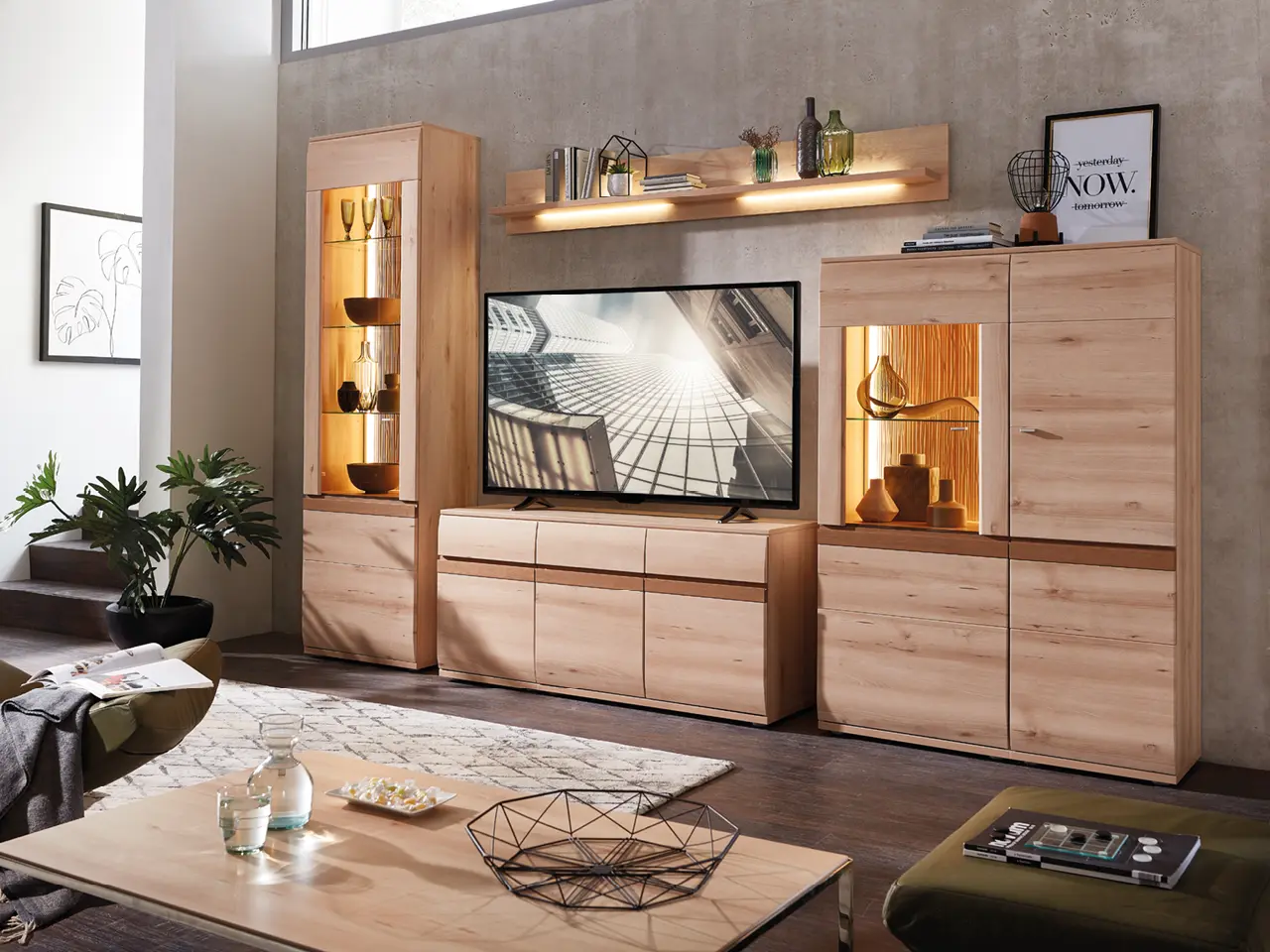 Wohnzimmer mit TV-Möbeln aus Holz, beleuchteten Vitrinen, Sessel und Couchtisch